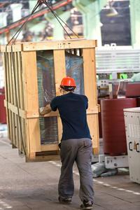 工厂工人运输货物箱用车间轨道安装龙门起重机照片
